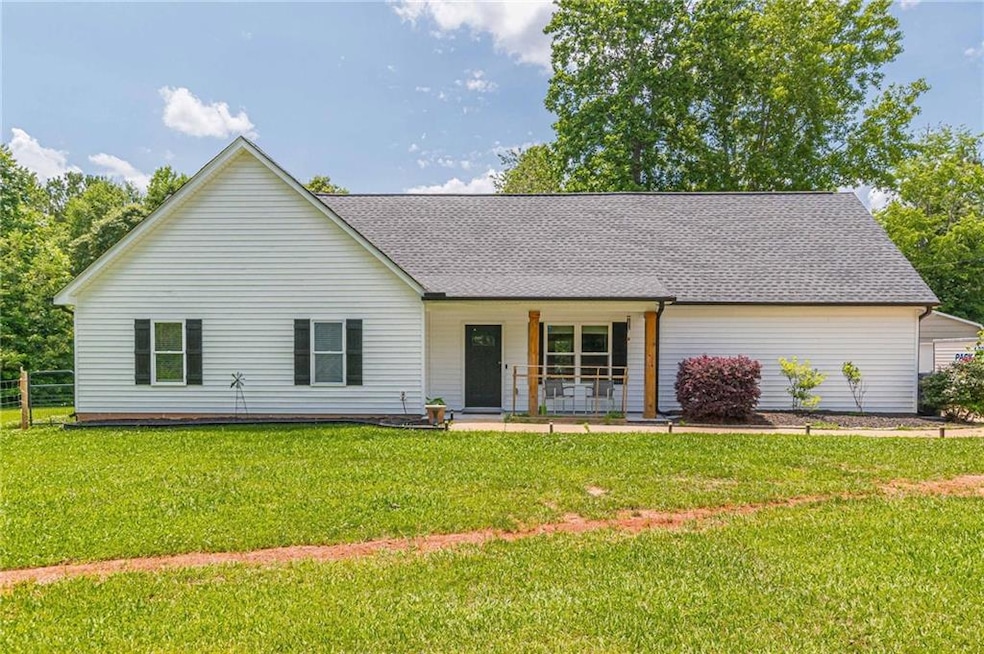 Ranch-style house featuring a porch and roof with shingles