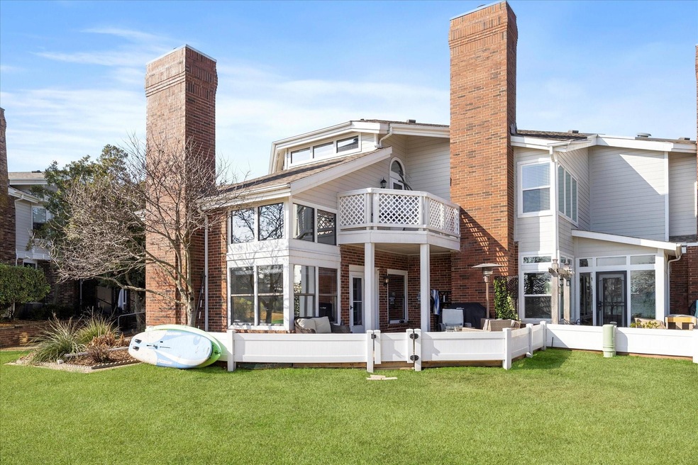 Rear view of property featuring a yard and a balco