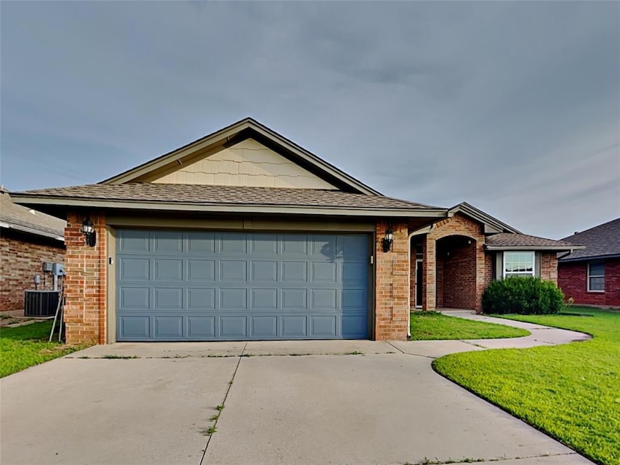 Single story home featuring concrete driveway, a garage, brick siding, and a front yard