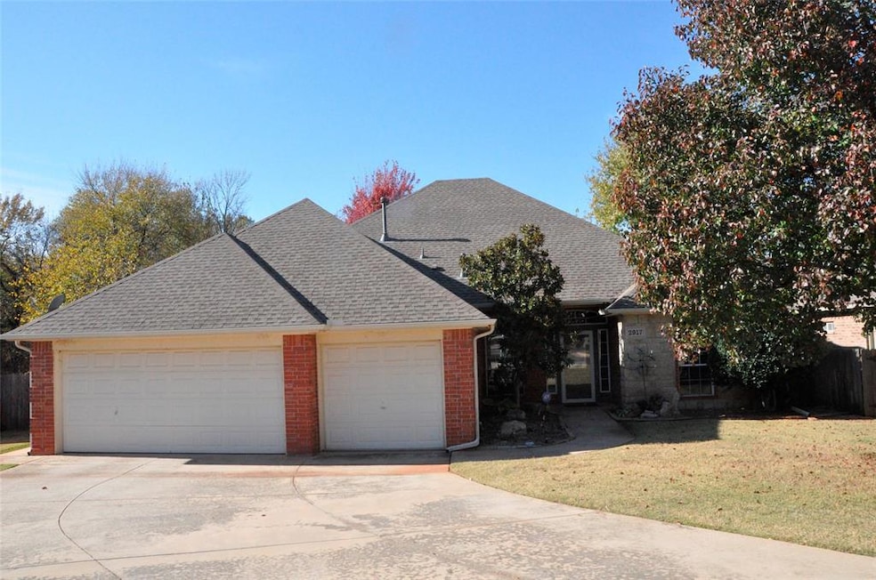 Traditional-style home with driveway, a shingled roof, brick siding, and an attached garage