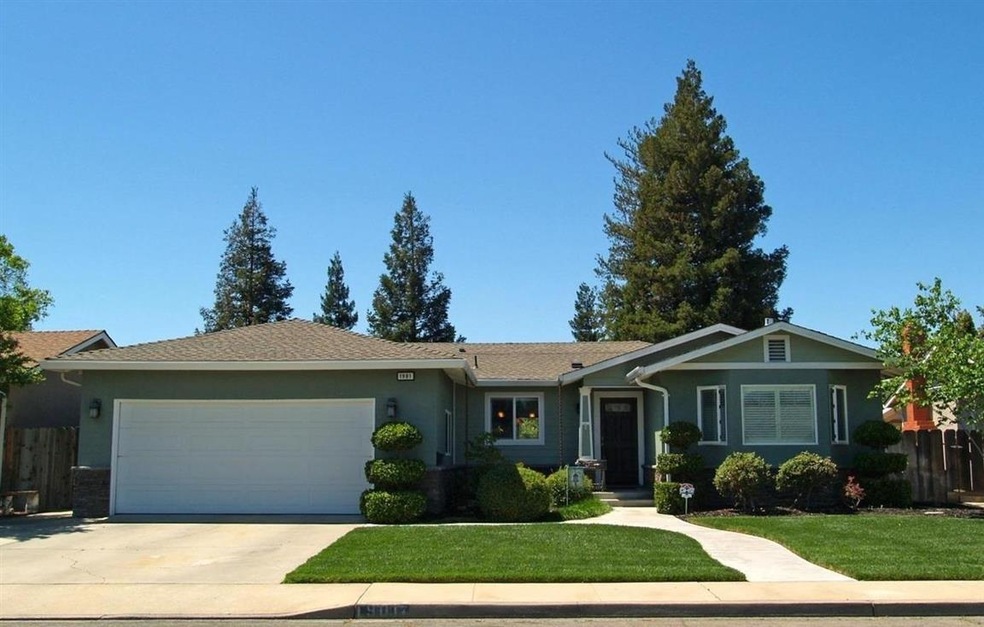 Front of home with landscaped yard and pond
