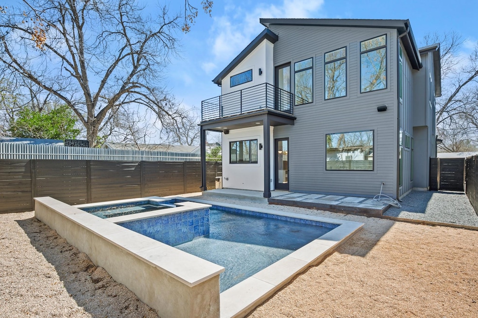 Rear view of house featuring an in ground hot tub
