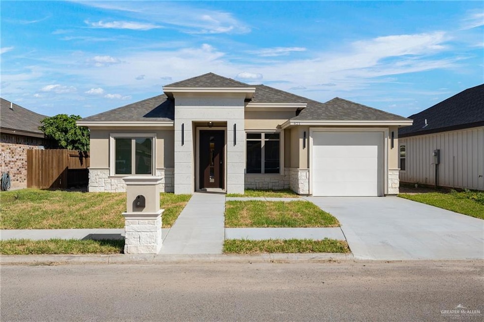 Prairie-style home with stone siding, a shingled roof, an attached garage, and stucco siding