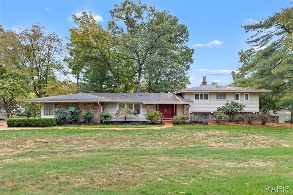 View of front of house with a front lawn, brick siding, and a chimney