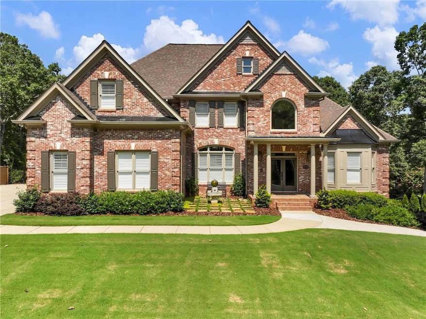 View of front of house with brick siding, french doors, and a front lawn