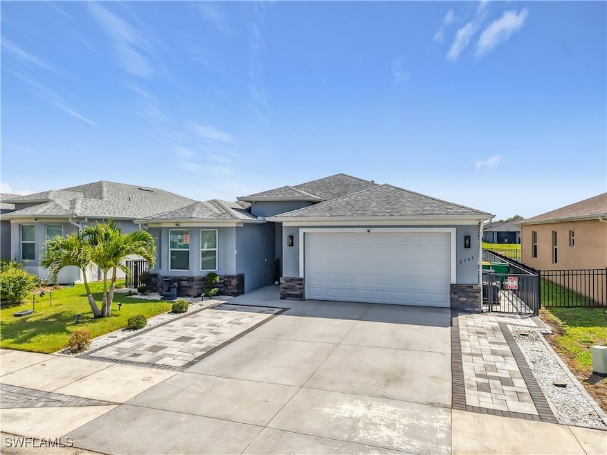View of front of home featuring a garage, fence, a