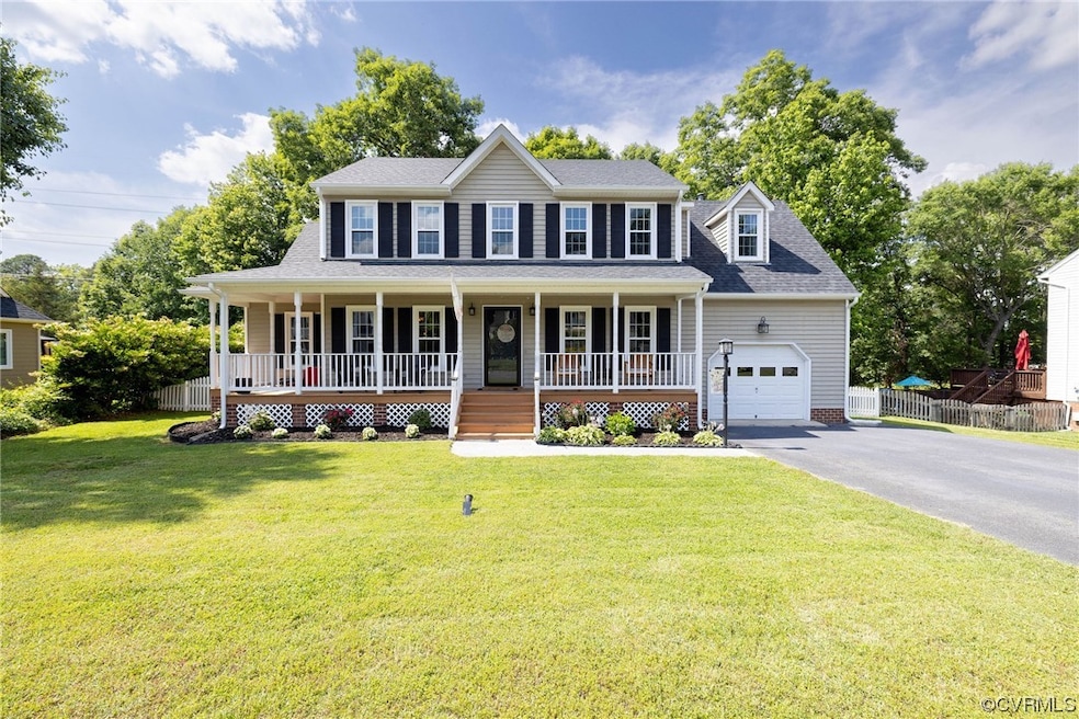 Colonial home featuring a porch, a garage, and a f