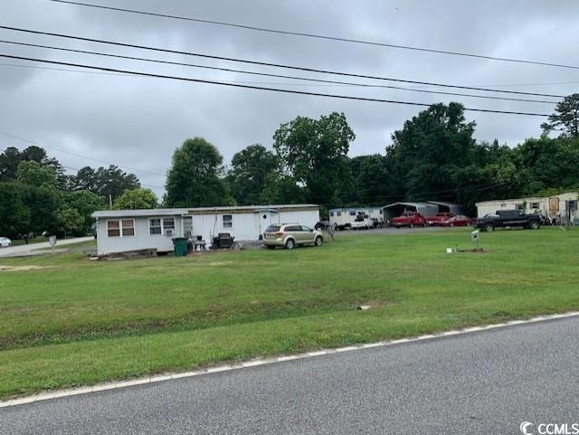 Manufactured / mobile home with a front lawn and uncovered parking