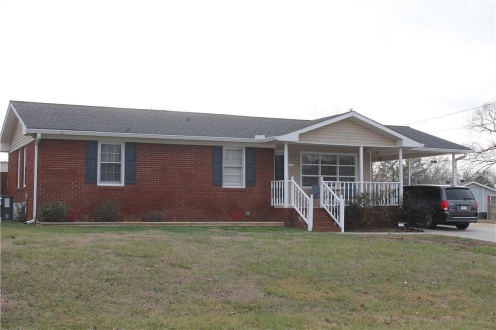 Single story home with a porch and a front yard