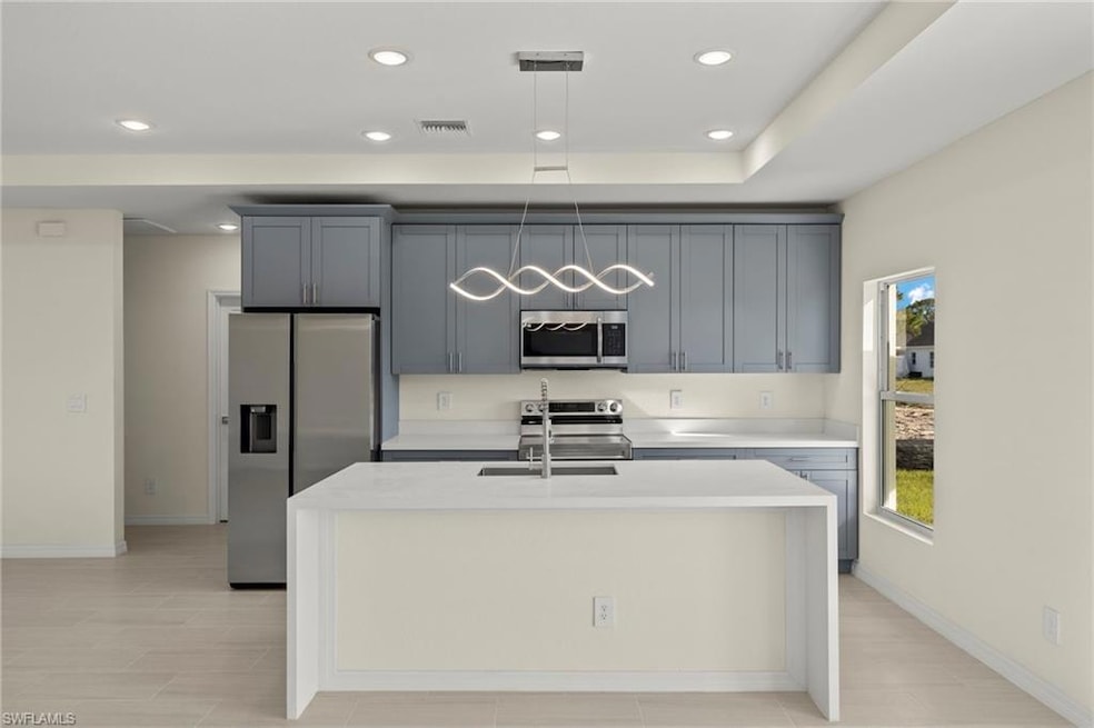Kitchen with an island with sink, sink, gray cabin