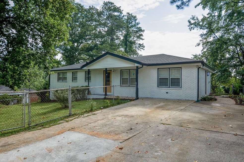 Single story home with covered porch, brick siding, and concrete driveway