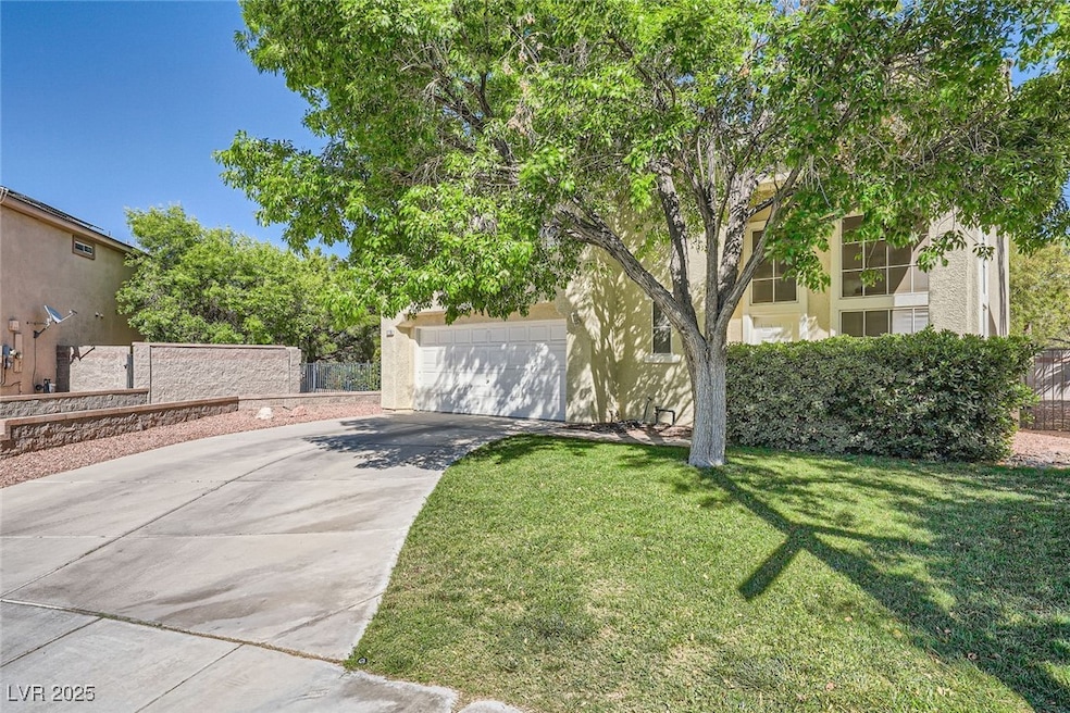 View of lawn with concrete driveway and an attache