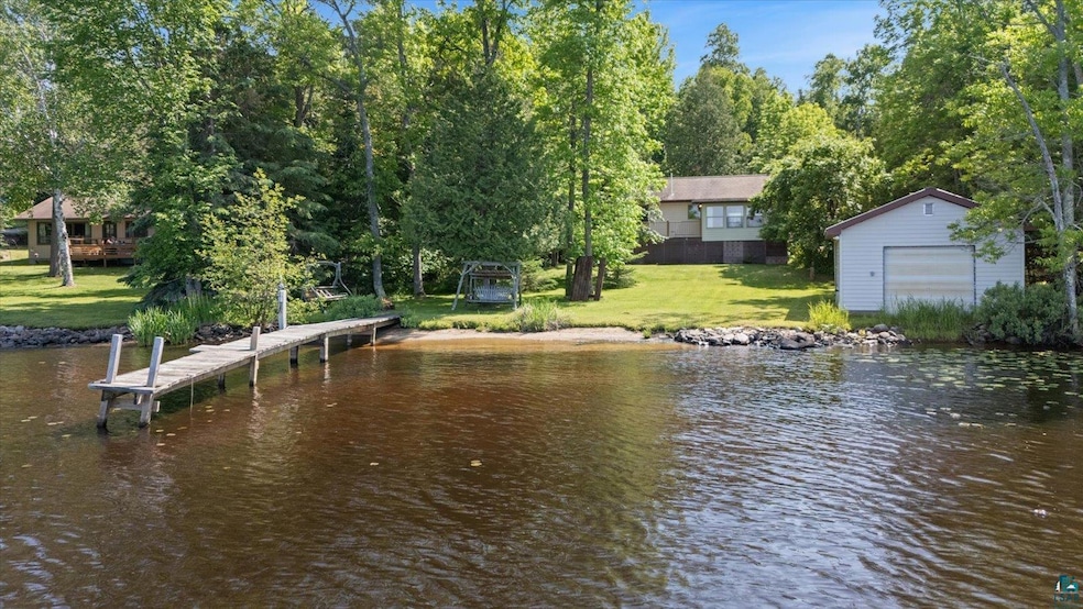 Dock area with a water view and a lawn
