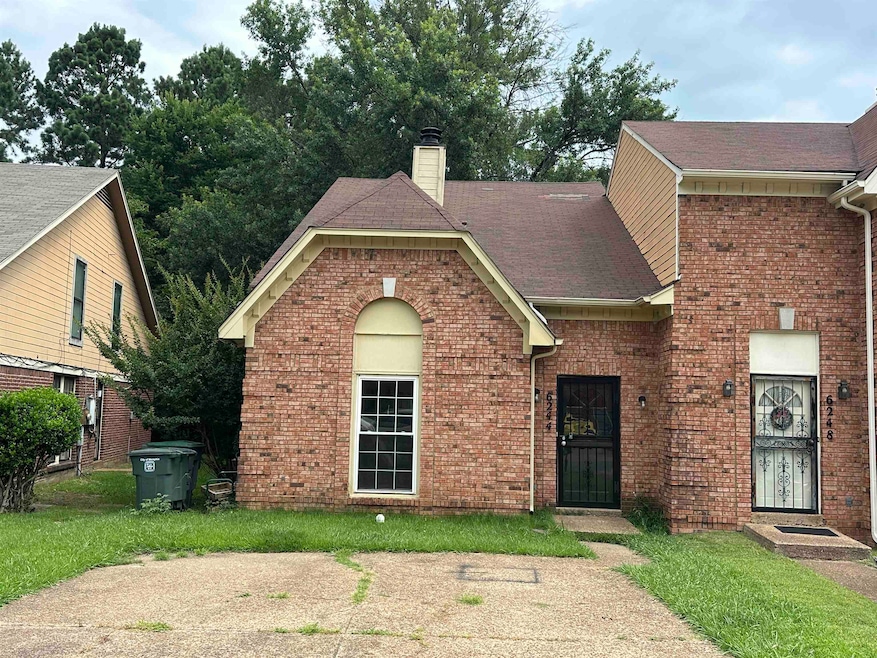 View of front of home with a chimney, brick siding, a shingled roof, and a front lawn