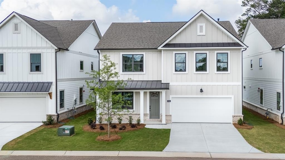 Modern farmhouse style home with a standing seam roof, concrete driveway, roof with shingles, and a garage