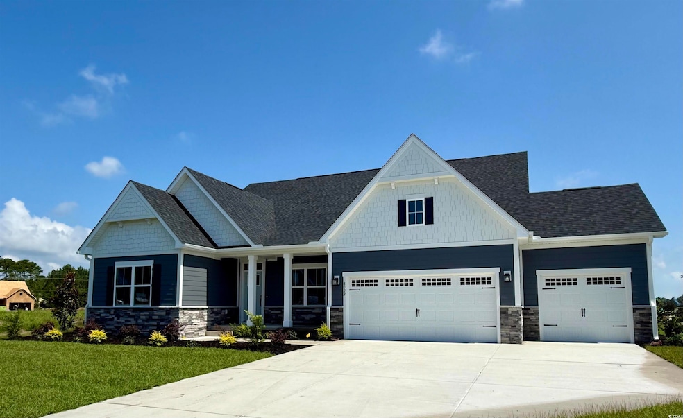 Craftsman house with stone siding, a garage, driveway, and a front yard