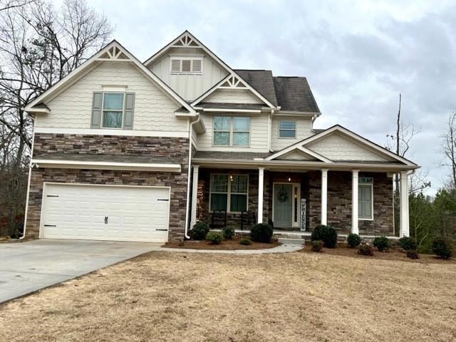 Craftsman house featuring covered porch and a gara