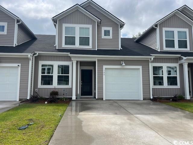 View of front of property with concrete driveway, an attached garage, and a front lawn