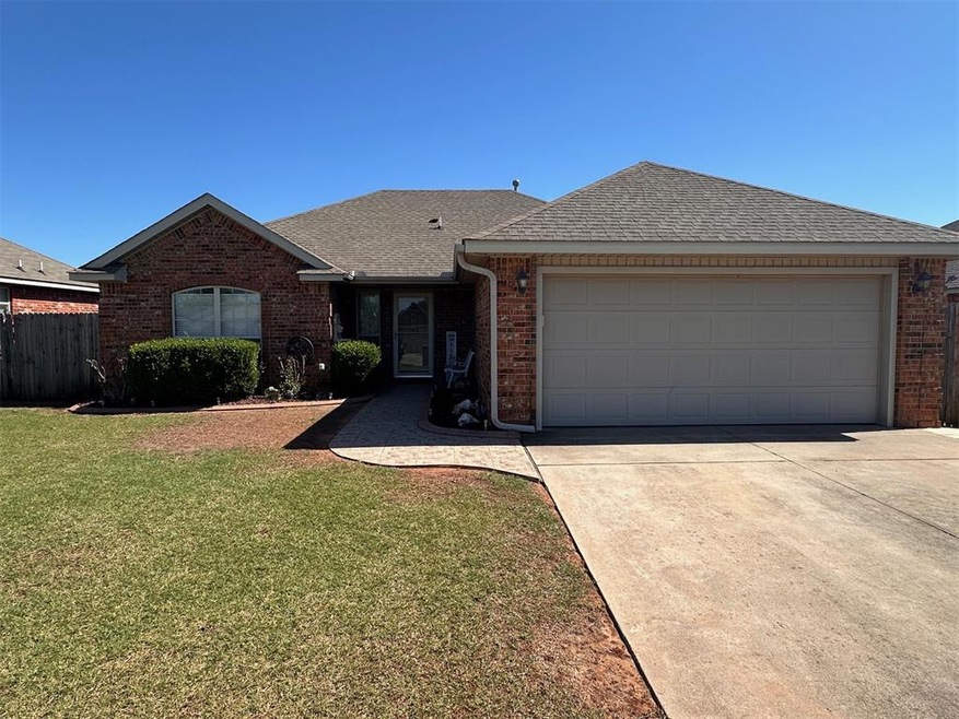 Single story home featuring brick siding, a shingled roof, and concrete driveway