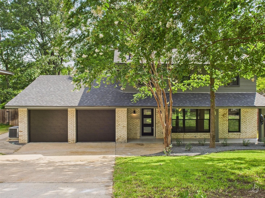 View of front of property featuring a shingled roof, concrete driveway, brick siding, and an attached garage