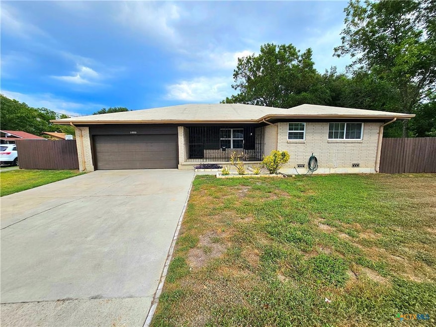 Ranch-style house with concrete driveway, brick s