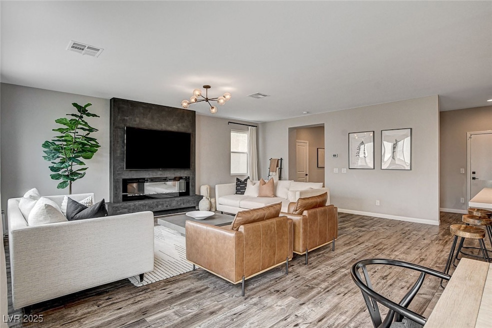 Living room with wood finished floors, a chandelie