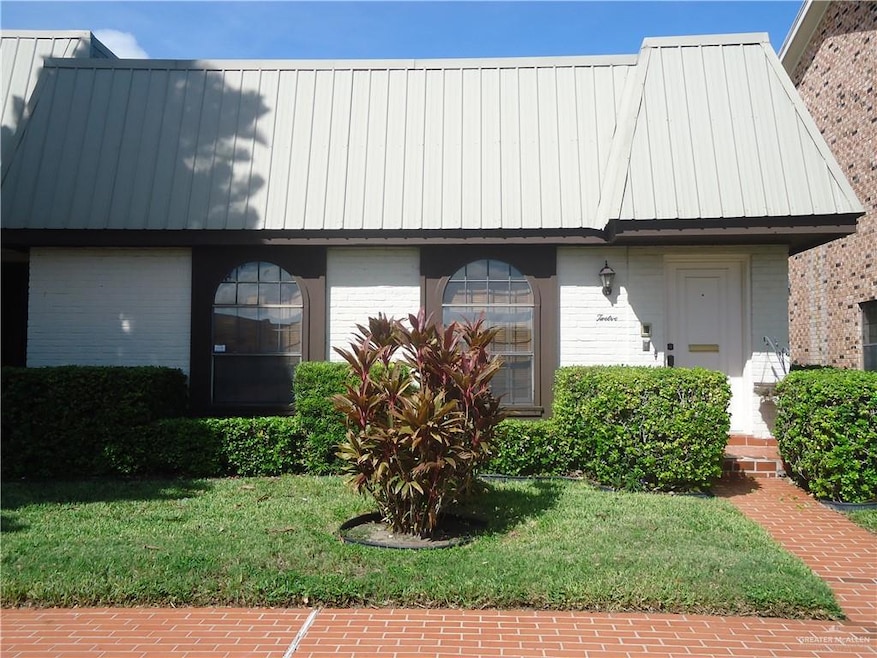View of front facade featuring a standing seam roof, a metal roof, and a front yard