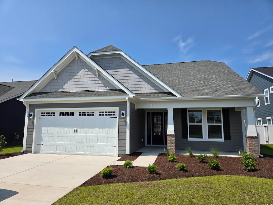 Craftsman inspired home featuring an attached garage, a porch, concrete driveway, and a front yard