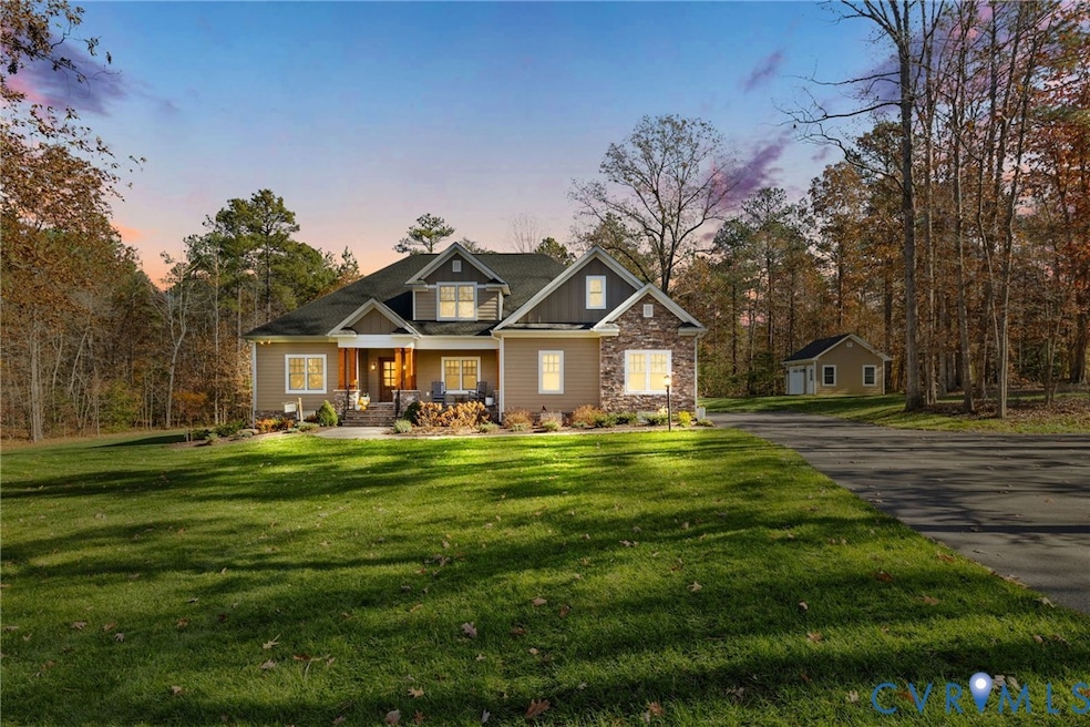 Craftsman-style house with covered porch, a lawn, board and batten siding, and stone siding