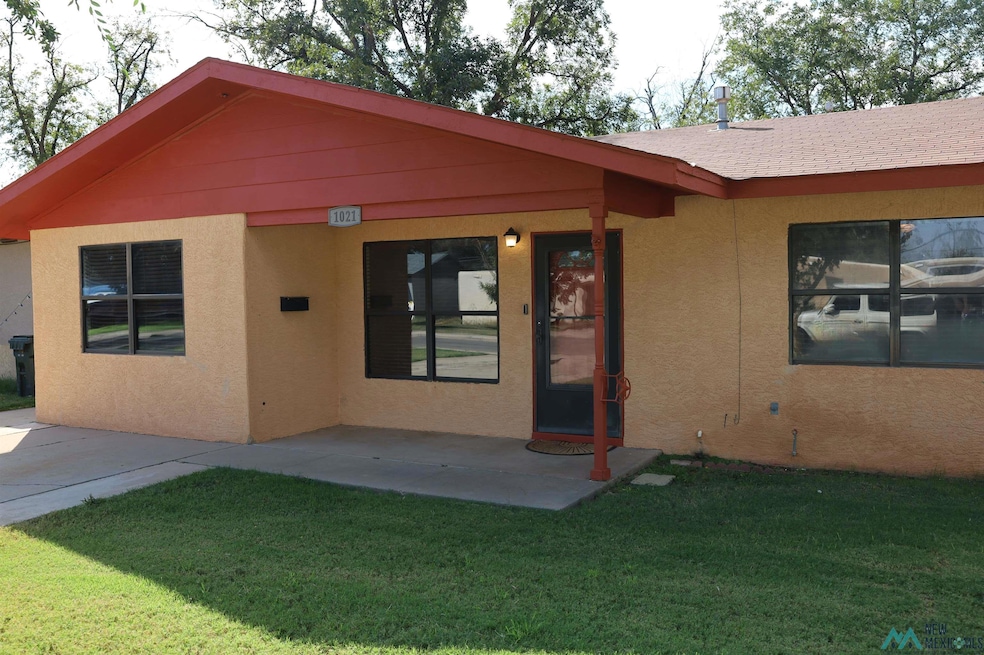 Back of house with a yard, stucco siding, and a patio area