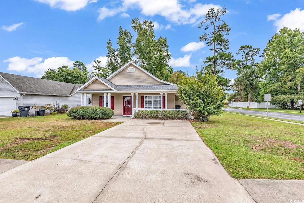 View of front of home driveway, yard and covered front porch