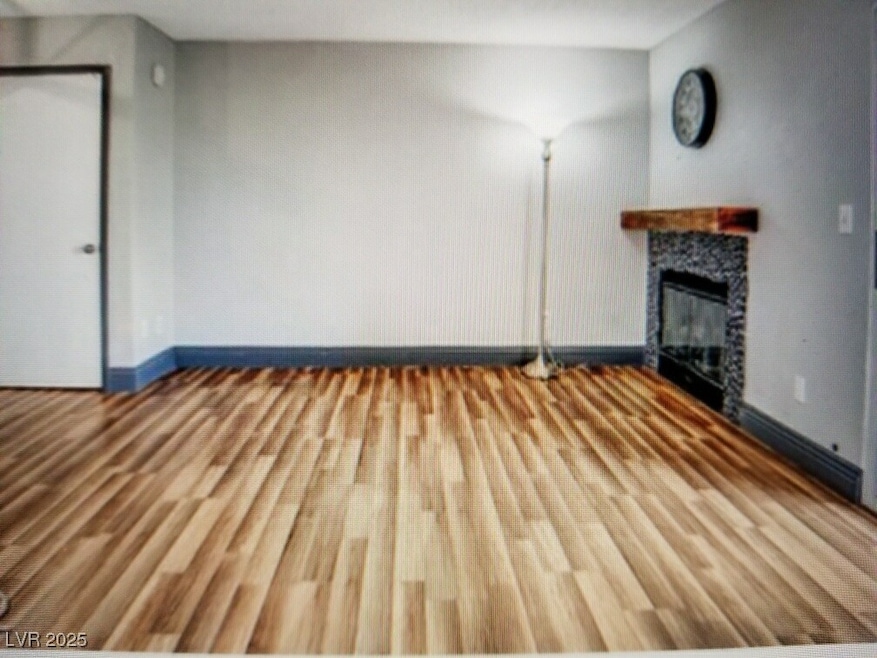 Unfurnished living room featuring a fireplace, woo