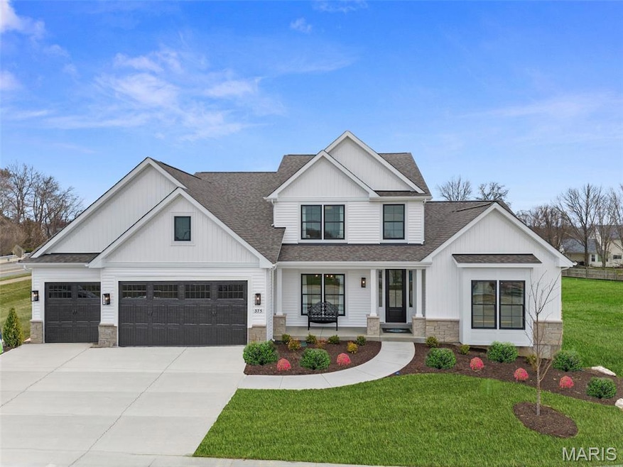 Modern inspired farmhouse featuring a shingled roof, a porch, stone siding, and concrete driveway