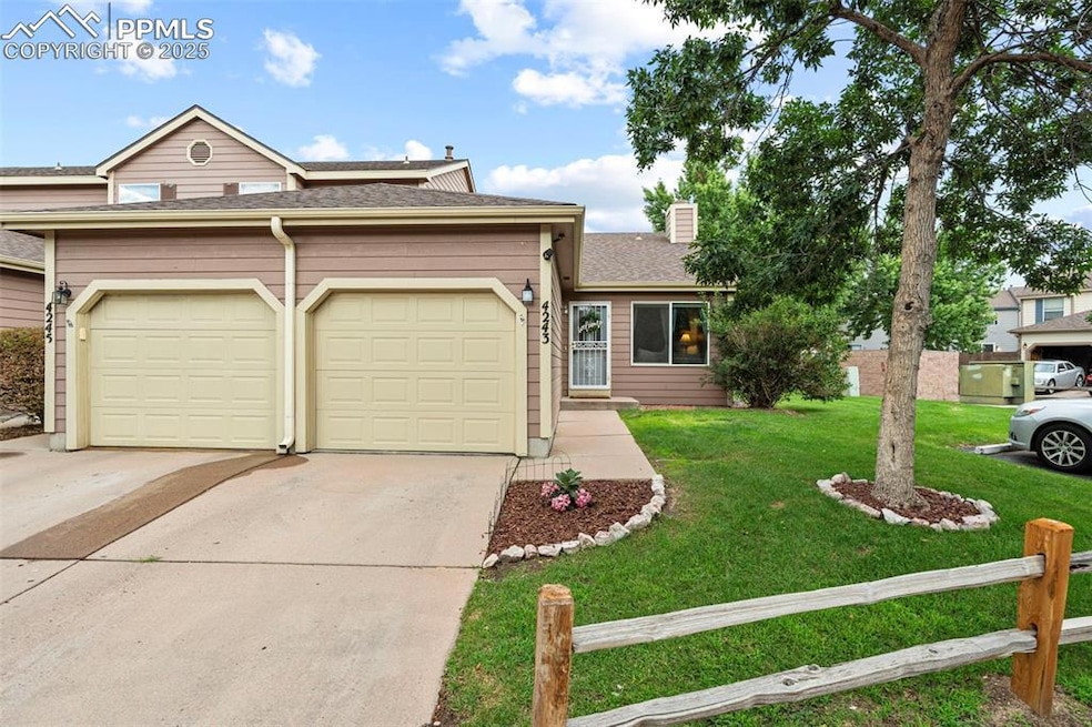 View of front of home with driveway, an attached garage, a front lawn, a chimney, and a shingled roof