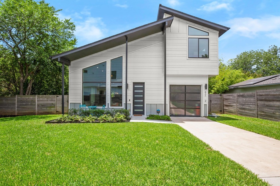 Rear view of house featuring driveway and a garage