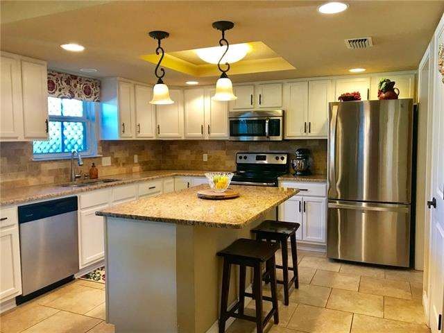 Tastefully updated kitchen with granite/stone/tile