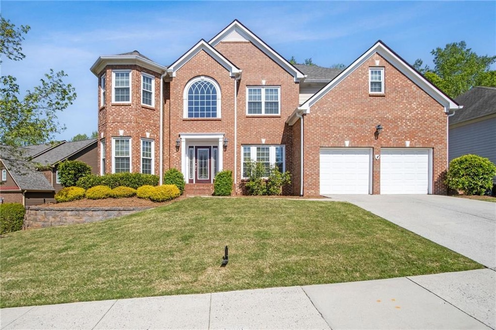 Colonial home featuring concrete driveway, brick s
