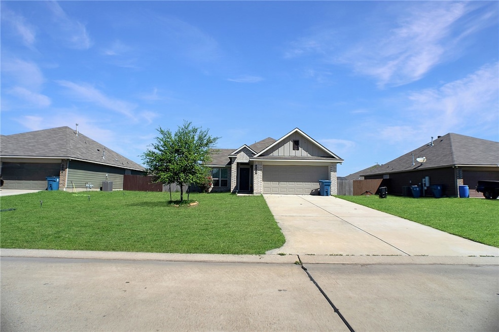 View of front of home with a front yard, driveway,