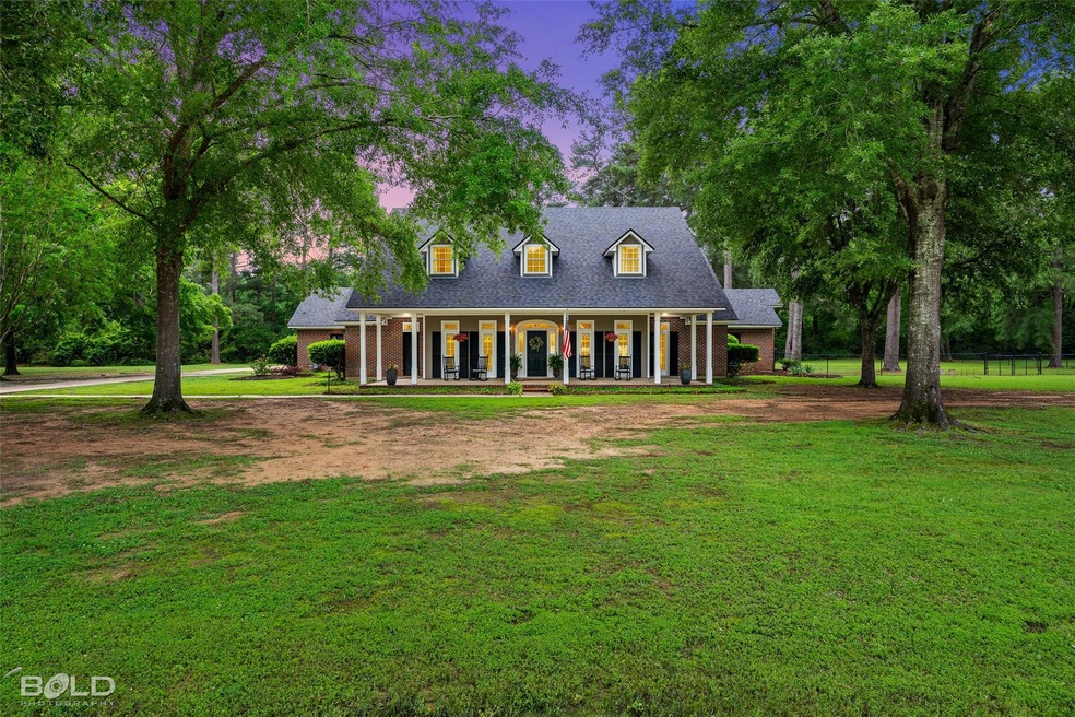 Cape cod house featuring a porch and a lawn