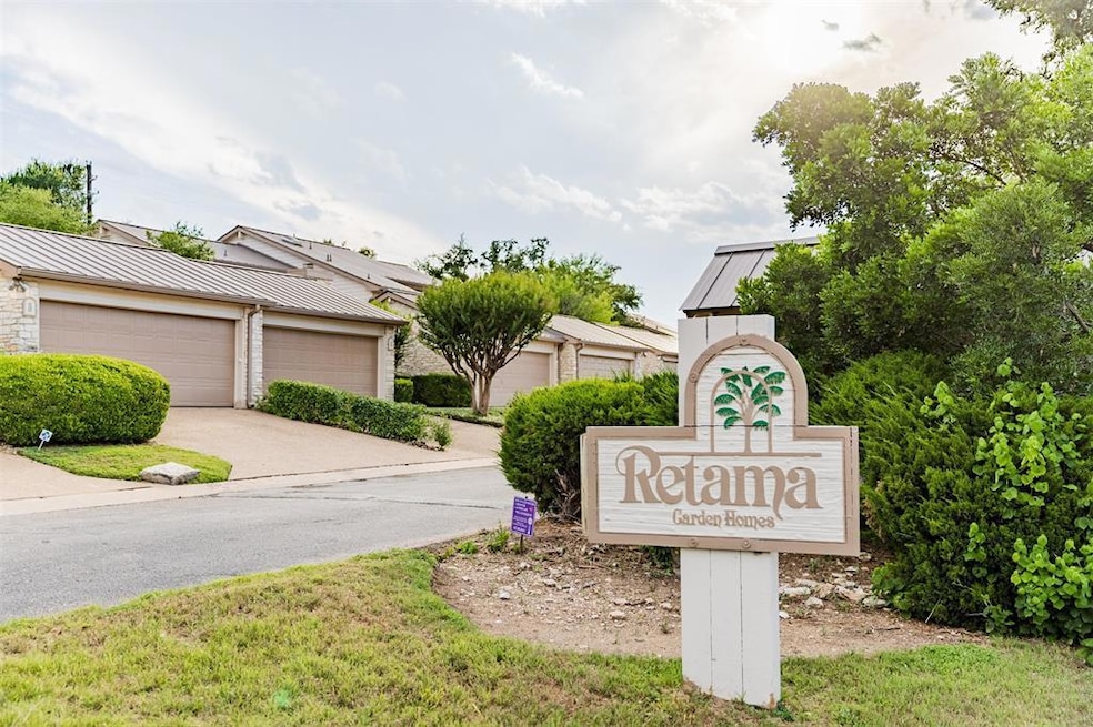 Community sign featuring concrete driveway and a 