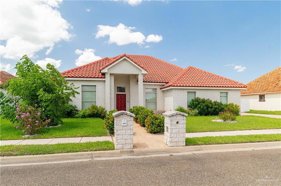 Front of home with a tile roof and a front lawn