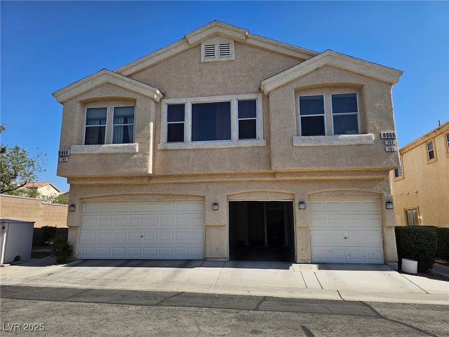 View of front of house with stucco siding and a ga