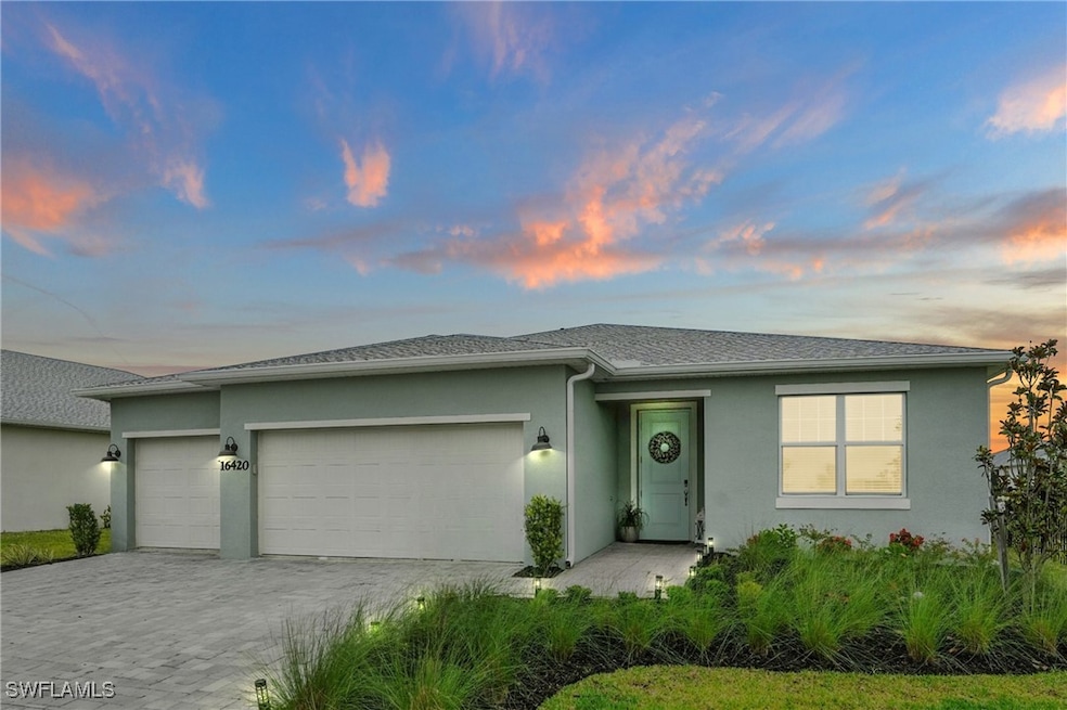 View of front of property with a garage, stucco si