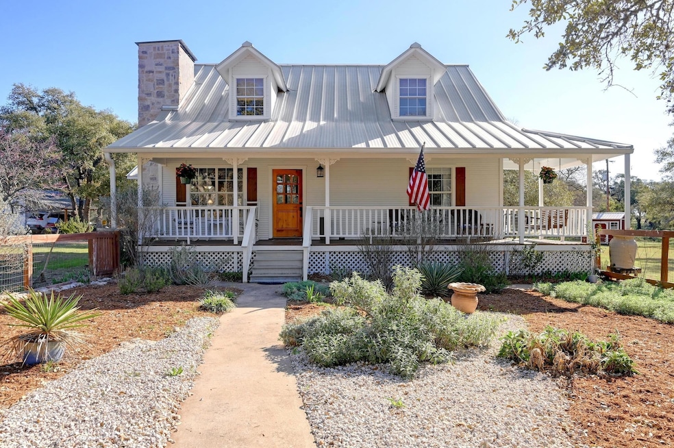 Country-style home with fence, a standing seam ro