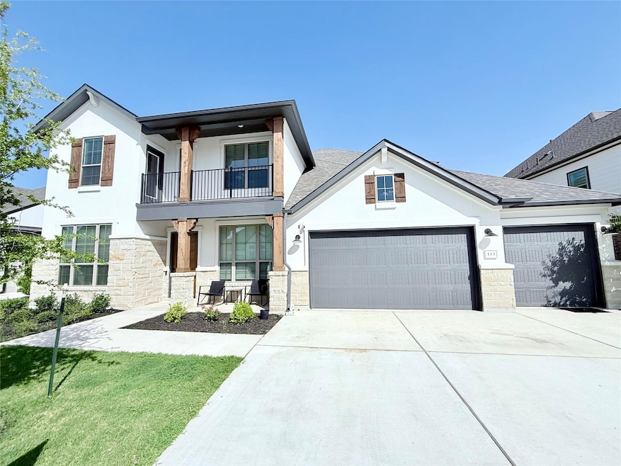View of front of home with stone siding, an attac