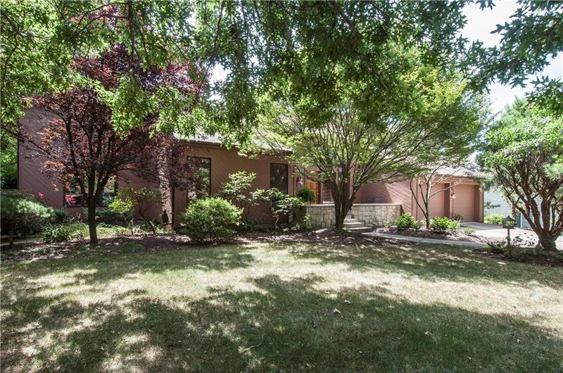 Professionally landscaped with an abundance of fol