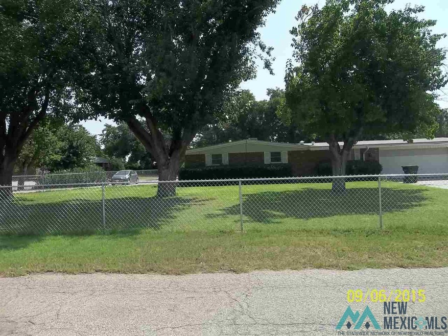 fenced west yard with shade trees