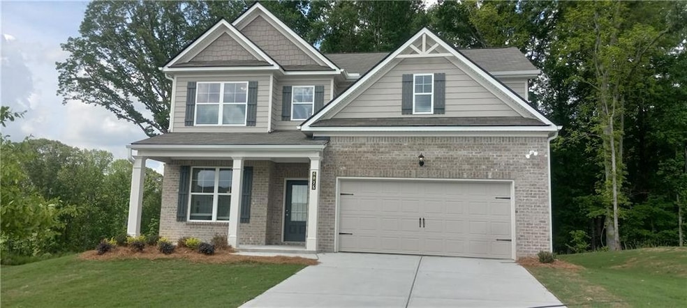 Craftsman-style home with concrete driveway, brick