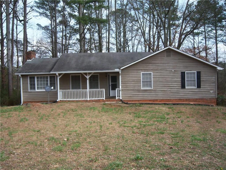 Ranch-style house featuring a chimney and a front lawn