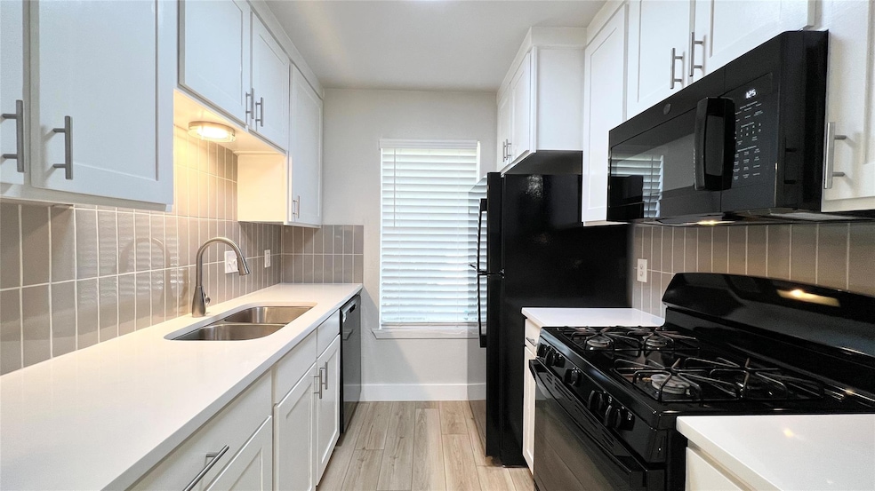 Kitchen featuring a sink, light countertops, ligh
